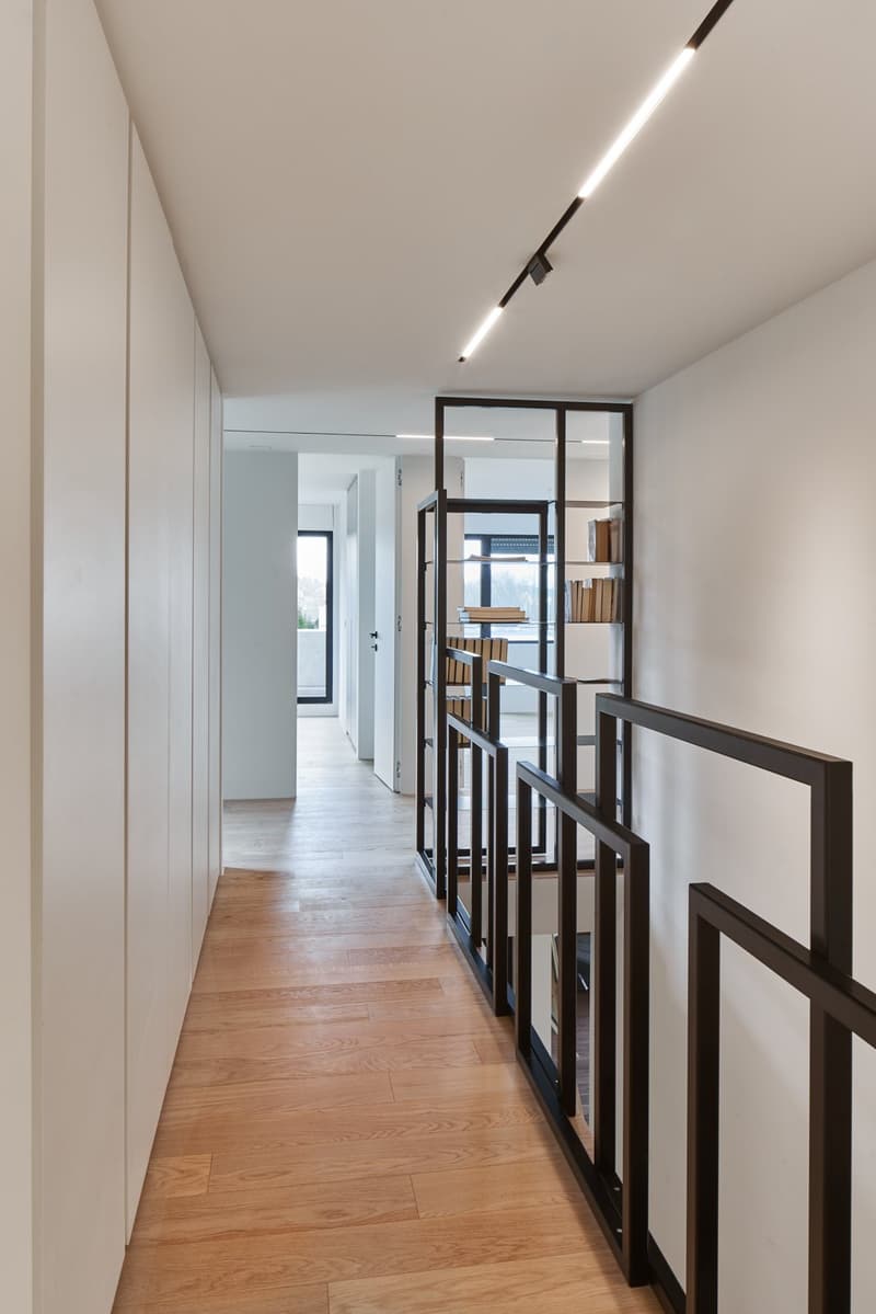 long hallway, wooden floor, white walls, glass doors, modern lighting