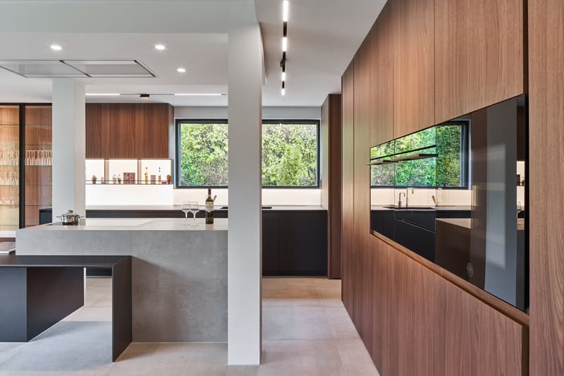 modern kitchen with island, wooden cabinets, large windows, wine glasses, bottle, sink, faucet, wine rack, wine glasses
