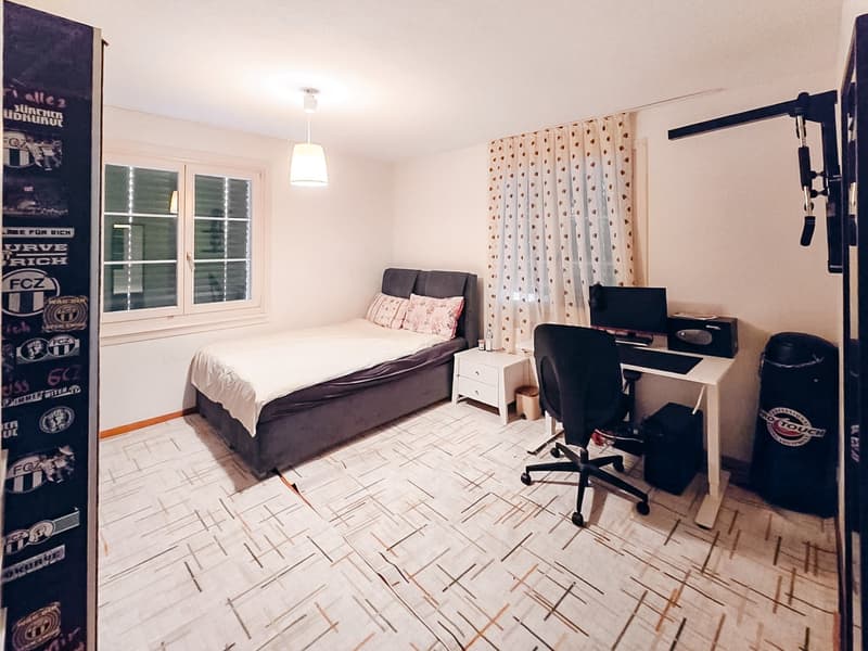 Single bed, desk, chair, monitor, night stand, window, curtains, lamp, punching bag