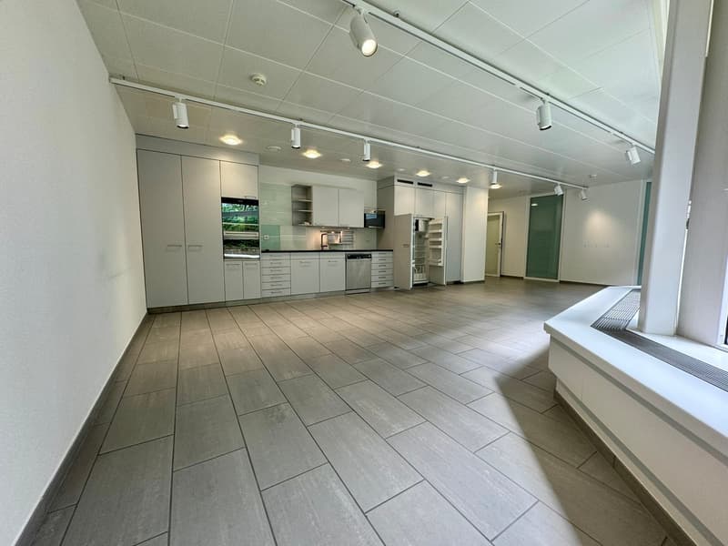 empty room, kitchen area with appliances and cabinets, tiled flooring, track lighting on ceiling