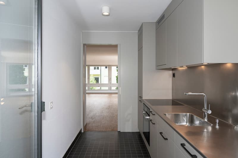 modern kitchen with stainless steel countertops, white cabinets, stainless steel sink, faucet, dishwasher, washing machine