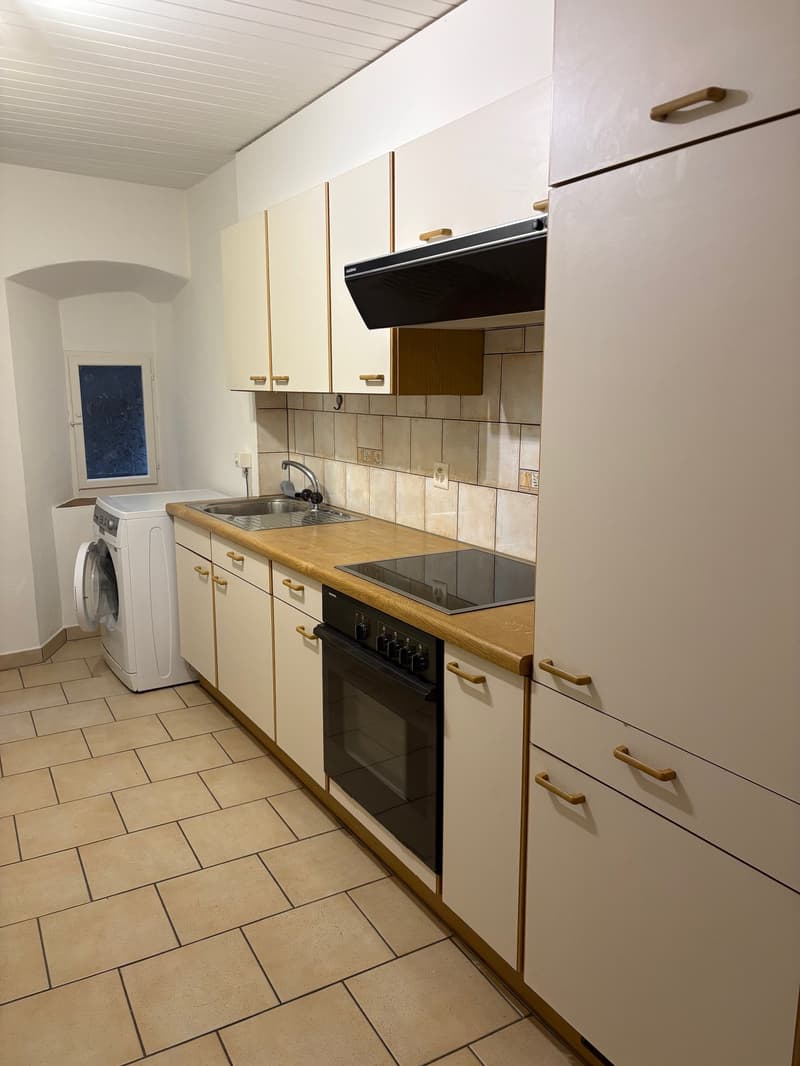 modern fitted kitchen with tiled floor, gas stove, wooden countertops, built-in cabinets, white appliances