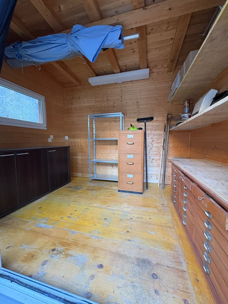 wooden floor, wooden walls, metal and wooden storage units, cabinet, drawers, small window, storage items, closed door