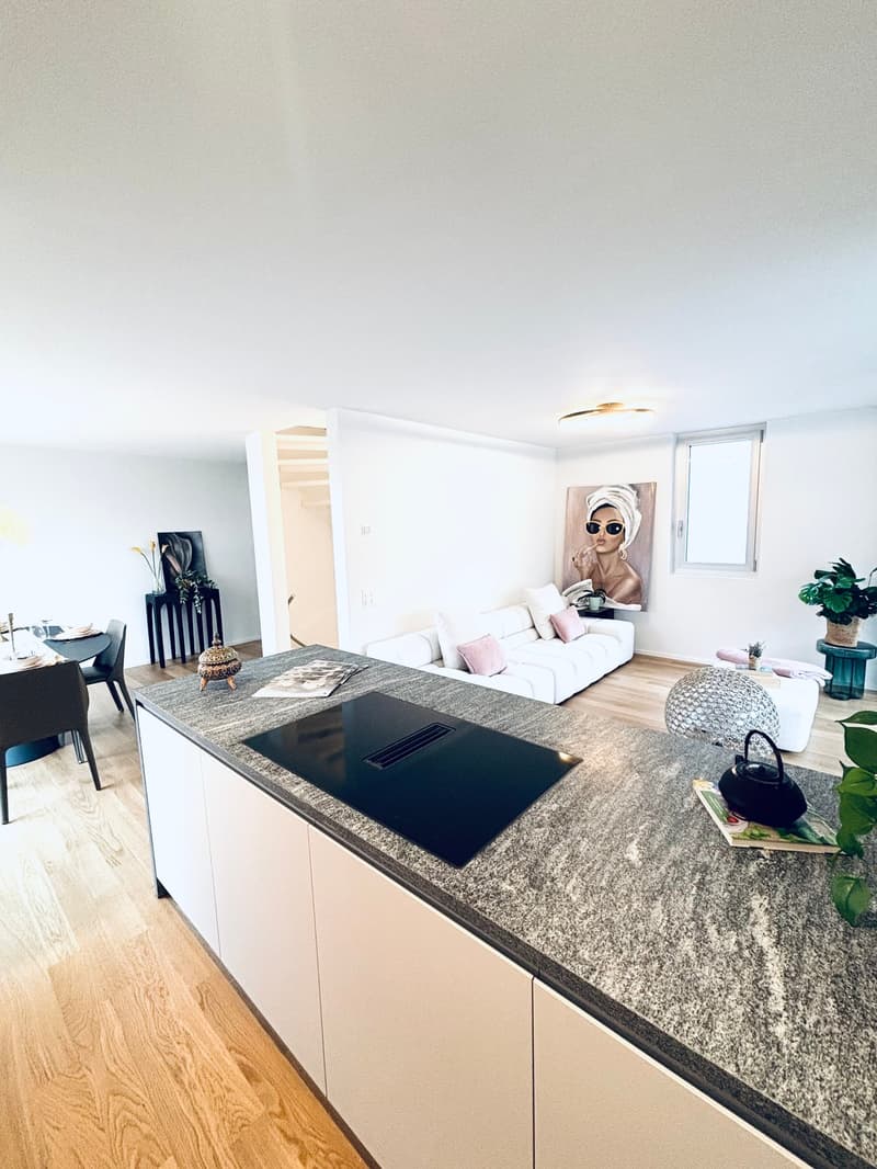 modern white kitchen with marble countertop, large glass windows, open living room with couch, dining table, dining chairs