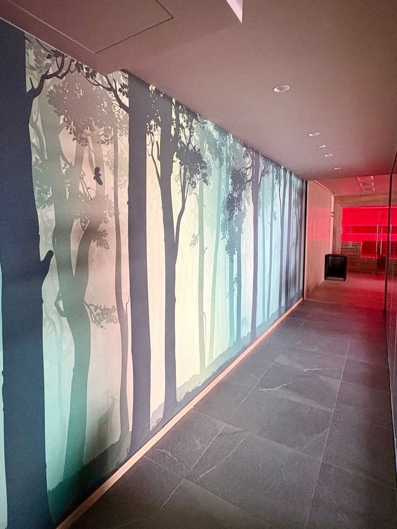 long hallway with a large wall mural, gray floor tiles