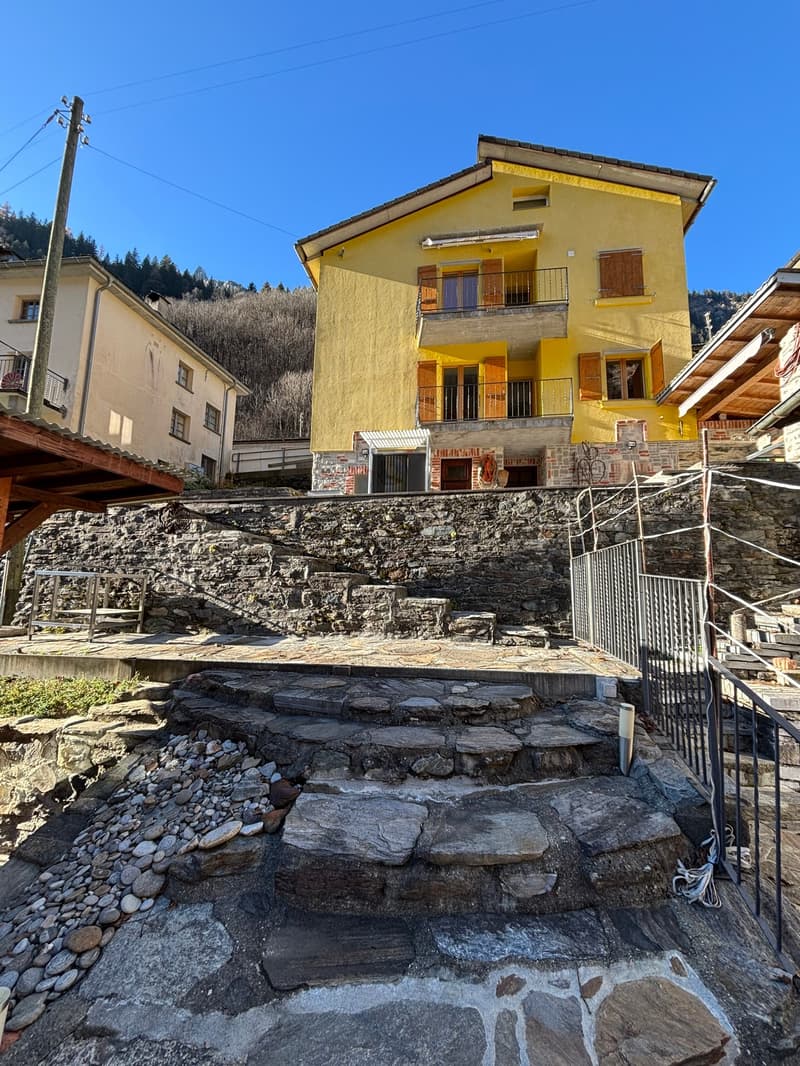 yellow house, stone wall, stone steps, balcony, mountain view