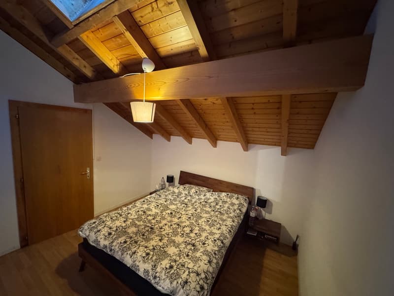 bedroom with wooden bed, wooden ceiling, wooden floor, lamp, nightstands with lamps, door