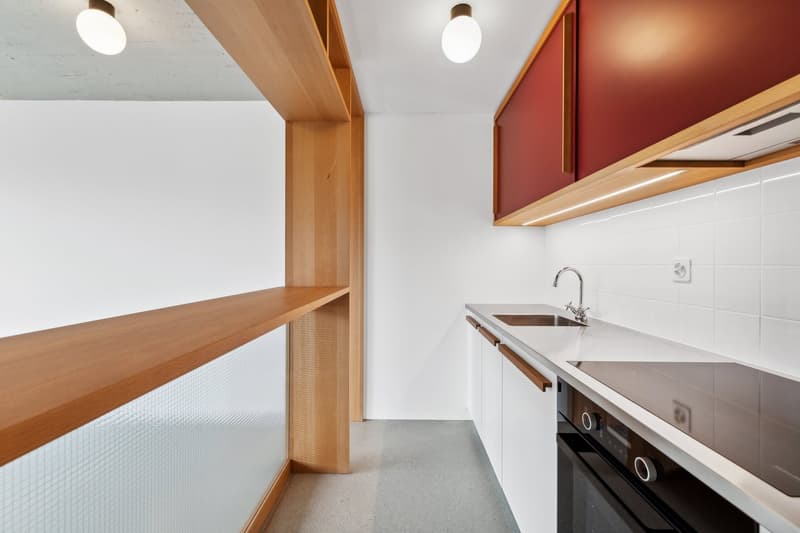 Modern kitchen with white cabinets, wooden countertops, built-in dishwasher, and open shelving