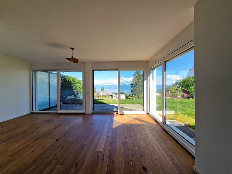 large room, hardwood floors, sliding glass doors, balcony, view of the lake and mountains
