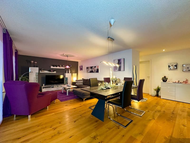 wooden floor, white walls, chandelier, couch, armchair, coffee table, TV, entertainment unit, dining table, chairs, floor lamp, plants, decorations