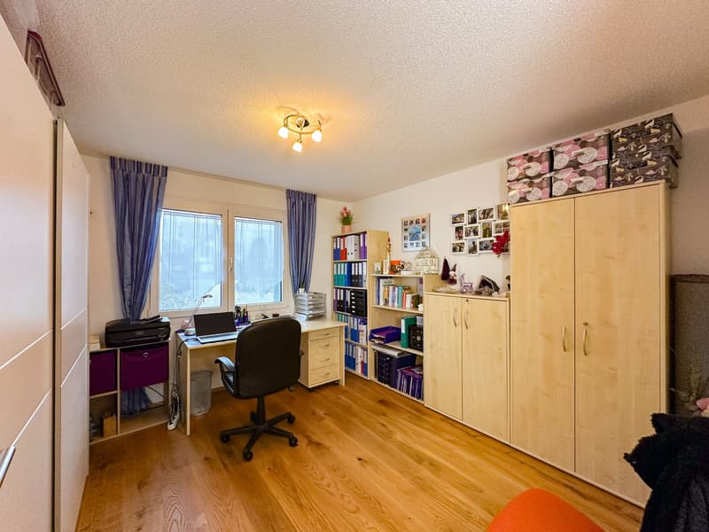 work area with desk, office chair, printer, windows, book shelves, cabinets, floor lamp