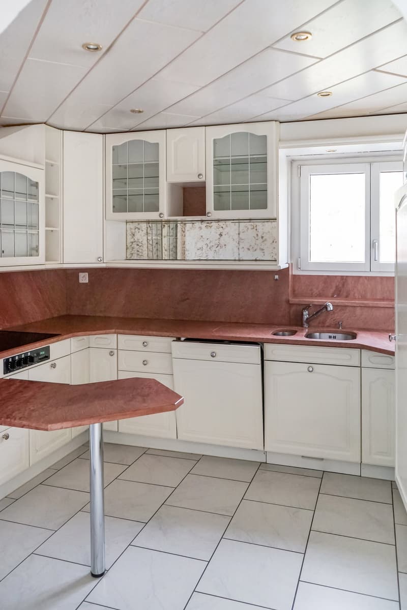 Modern kitchen, white cabinets, red countertops, stainless steel appliances, central island, white tiles, dishwasher and washing machine