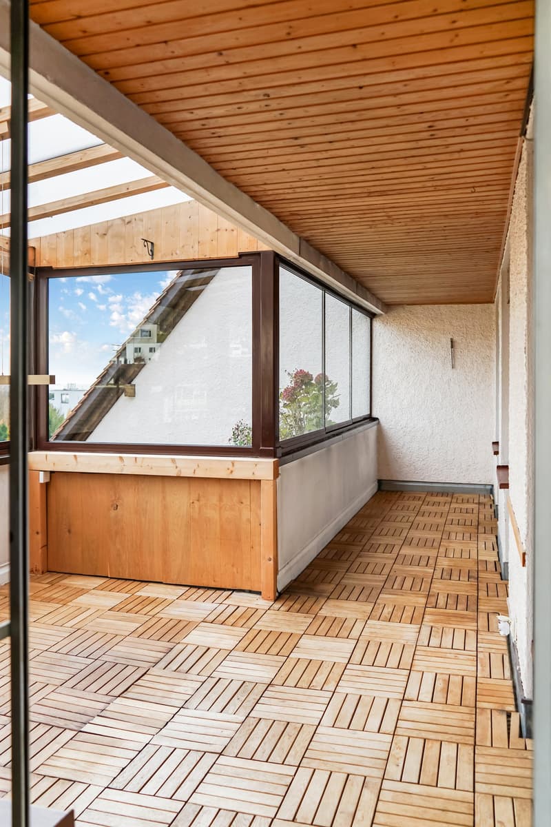 covered terrace with wooden deck, glass windows, sloped ceiling, open entrance, plant