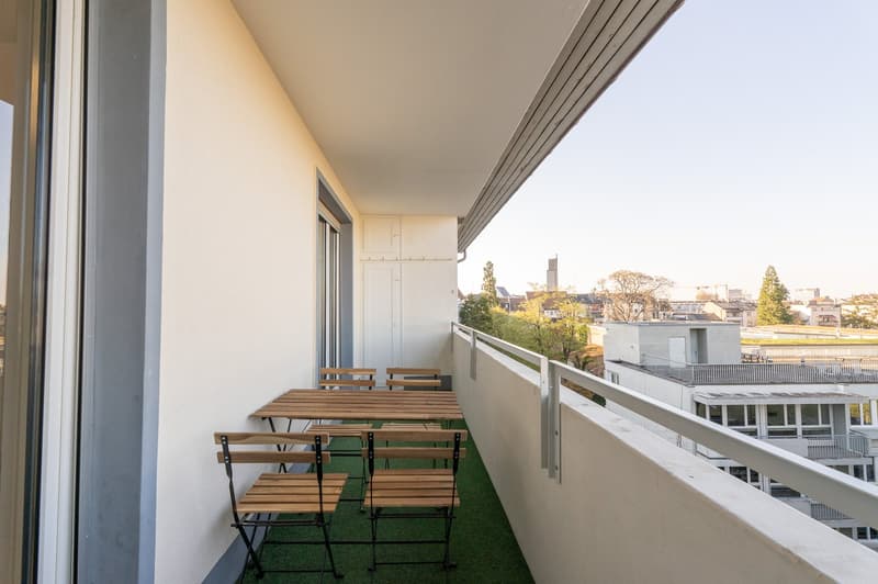 outdoor balcony with dining furniture, artificial grass, metal railing