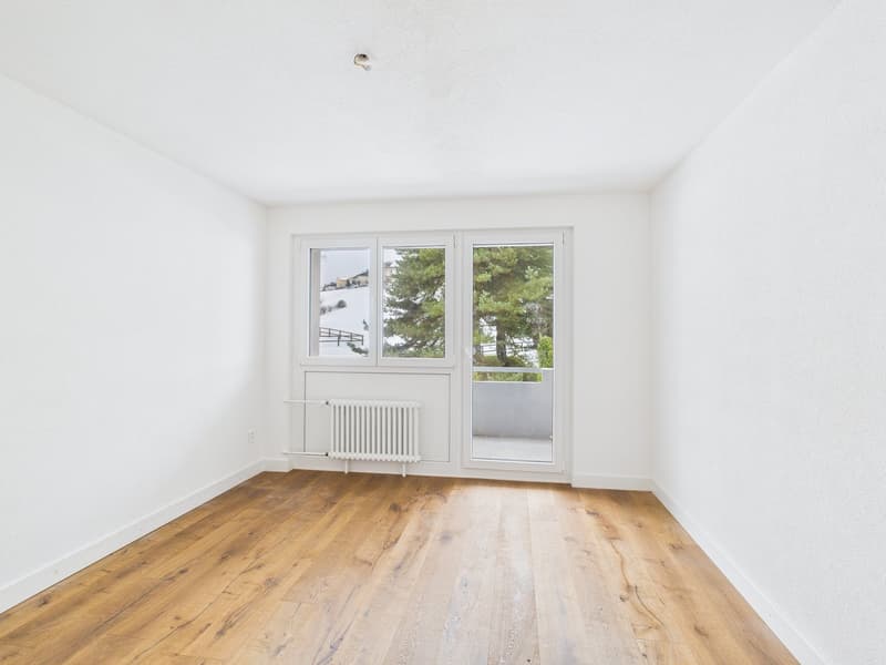 empty room, white walls, wooden floor, large windows, balcony, trees outside