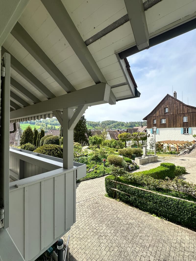 balcony, wooden beams, brick floor, view of garden and village