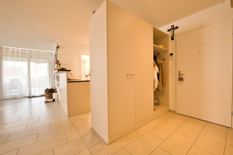 Empty room with a large wardrobe, cross on the wall, white curtains