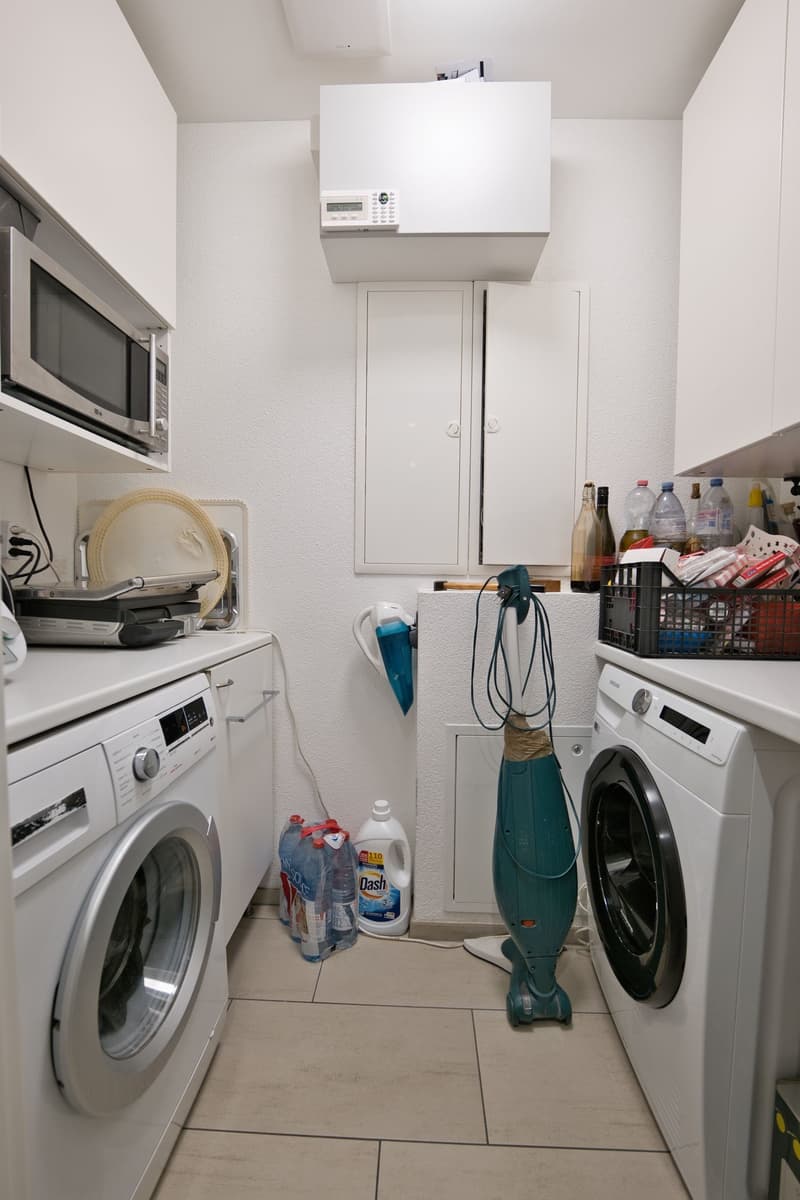Washing machines, countertop, cabinet, microwave, cleaning products, bottles, basket
