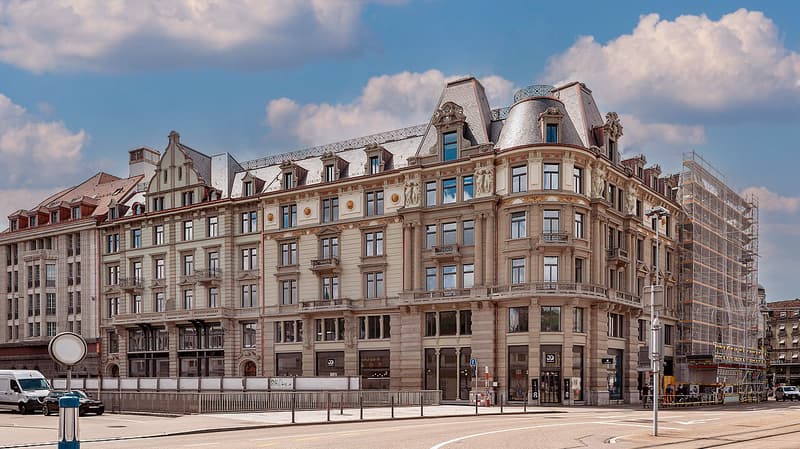 4 story building, brick facade, ornate balconies, large arched windows, red roofs, street facade