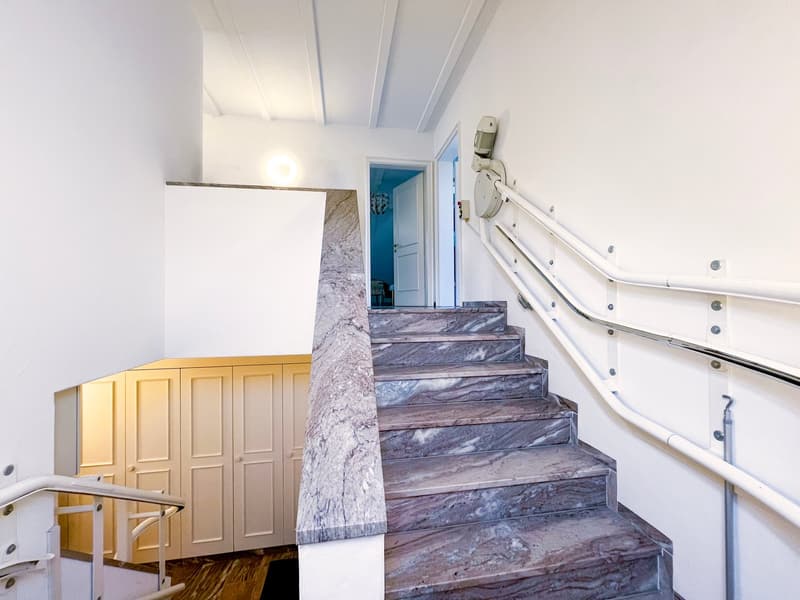 marble staircase, white handrail, white walls, wooden floor