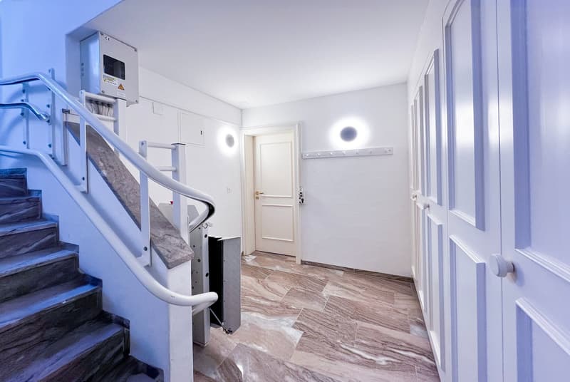 marble floor, white walls, white doors, elevator, stairs, light fixtures