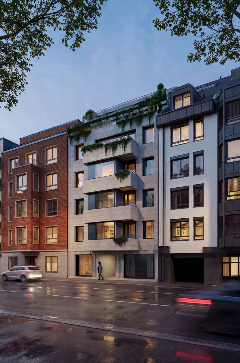 Modern apartment building with multiple balconies, brick and concrete facade, large windows, and a green rooftop garden.