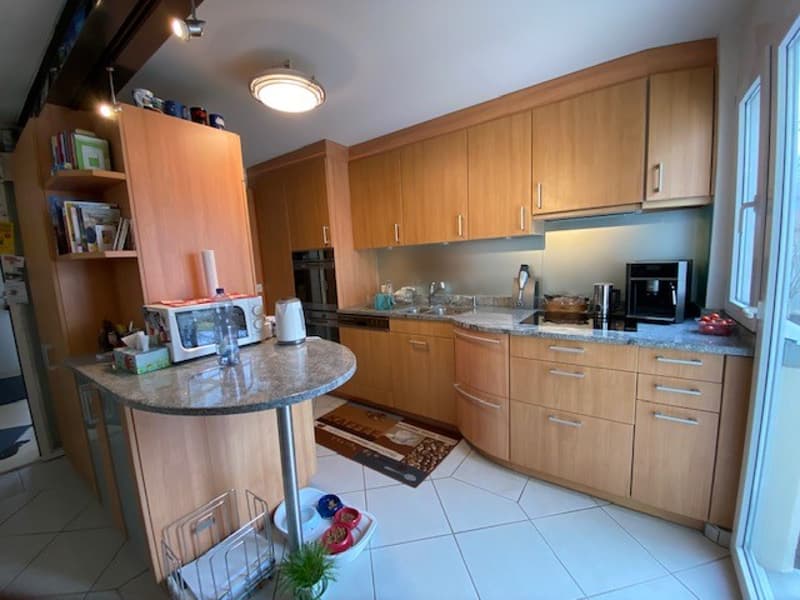 Lighting above the countertop, sink, stainless steel appliances, kitchen cabinets, tiled floor