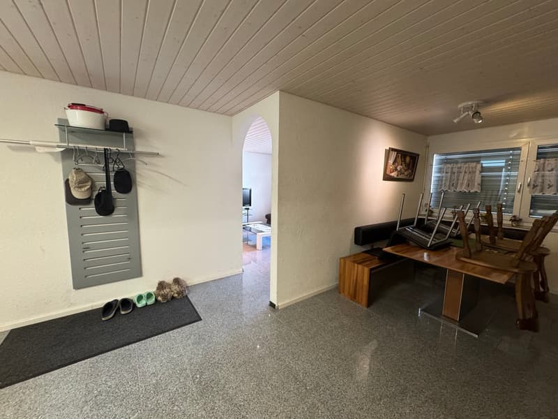 Entrance hall with coat rack, shoes, and a desk with chairs