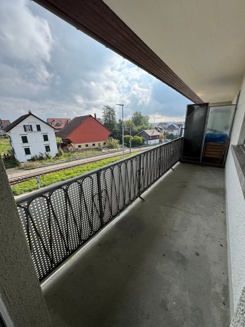 Balcony with metal railing, concrete floor, view of houses and landscape