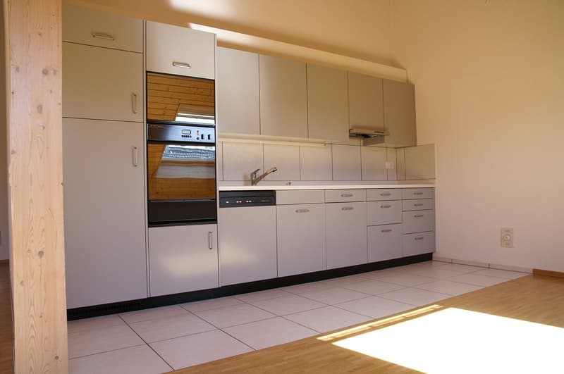 modern kitchen with white cabinets, tiled floor, stainless steel appliances, wooden pillar