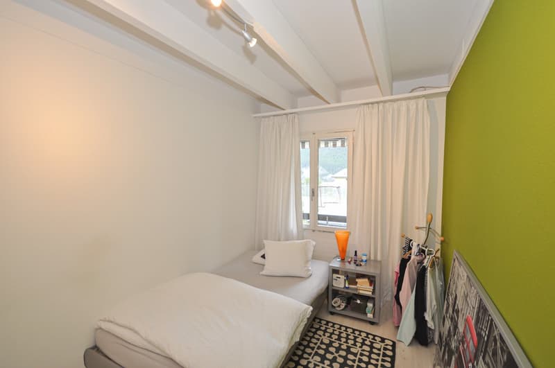 bedroom, single bed, pillows, nightstand, clothes rack, window with white curtains, clothes hanging, large black and white print on the wall