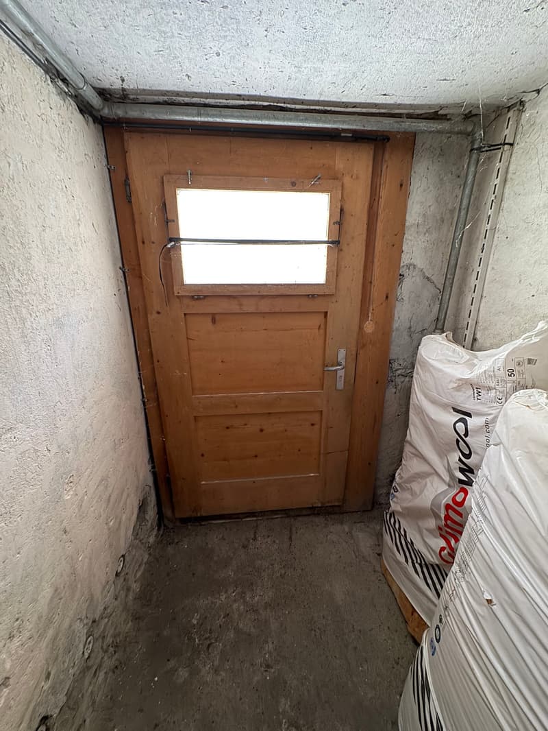 Single storage room with wooden door and window