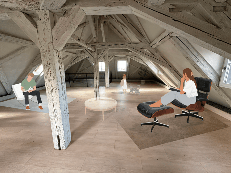 Spacious attic with exposed wooden beams, large windows, and a fireplace. The room has a minimalist design with a lounge chair, coffee table, and a person sitting on the floor.
