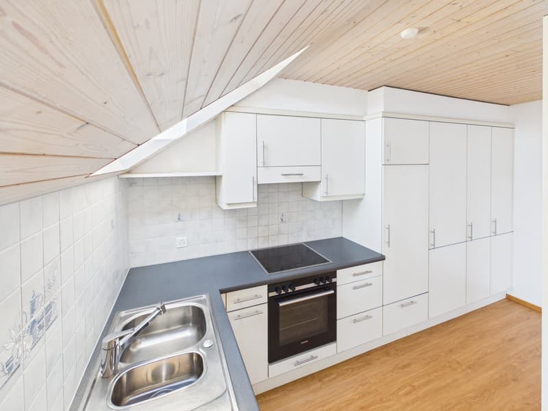 modern kitchen with white cabinets, wooden ceiling, stainless steel sink, black stove, oven, wooden floor