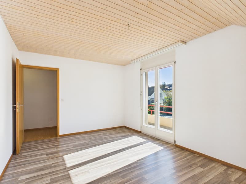 empty room, wooden floor, white walls, sliding glass doors to balcony, wooden ceiling