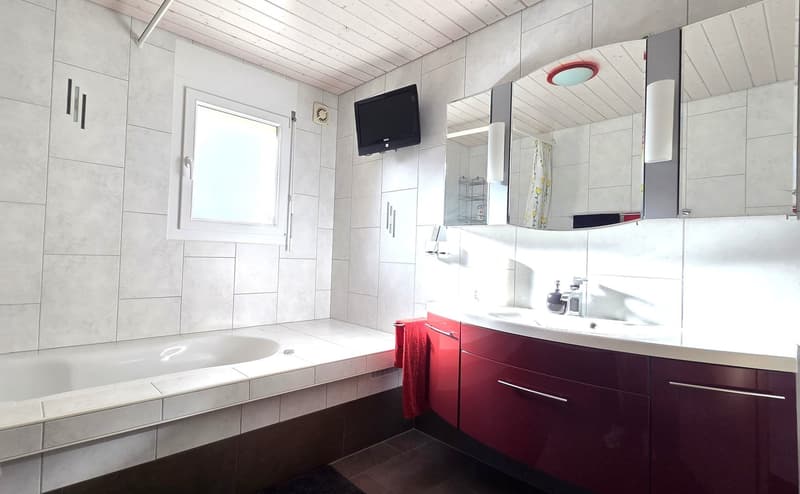 modern bathroom, white tiles, bathtub, sink, mirrors, tv, red cabinet