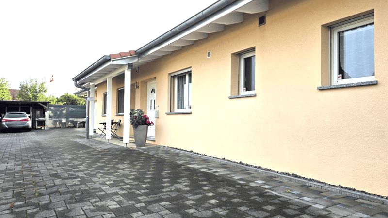 detached house, beige painted, garage, brick driveway, flower pot