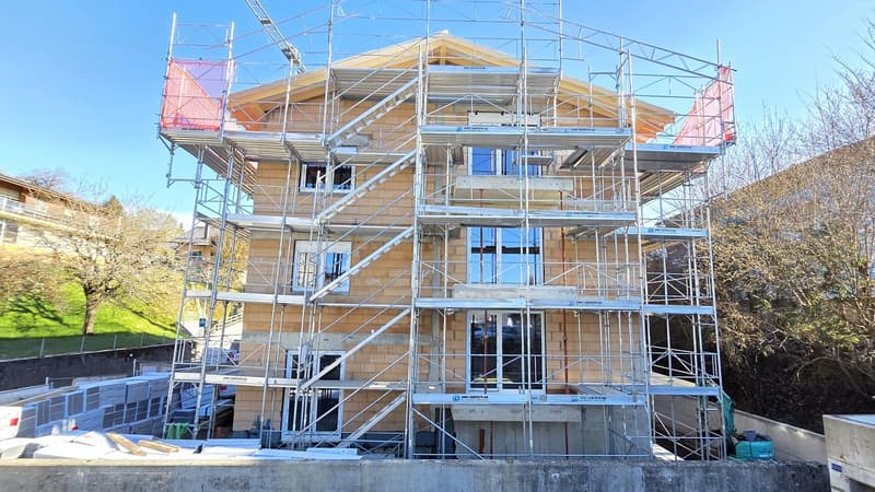 House under construction, brick walls, glass windows, scaffolding, multiple floors