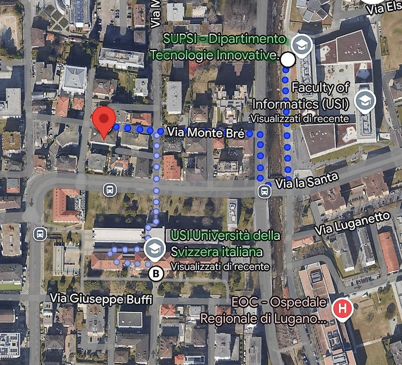 Urban area with buildings, road signs, and a campus.