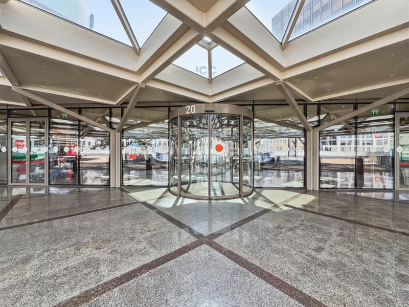 modern building, glass walls, revolving door, marble floor, high ceiling, glass roof