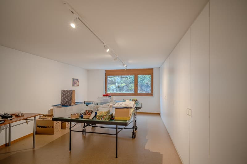 empty room, white walls, wooden floor, large windows, table with boxes, cabinets