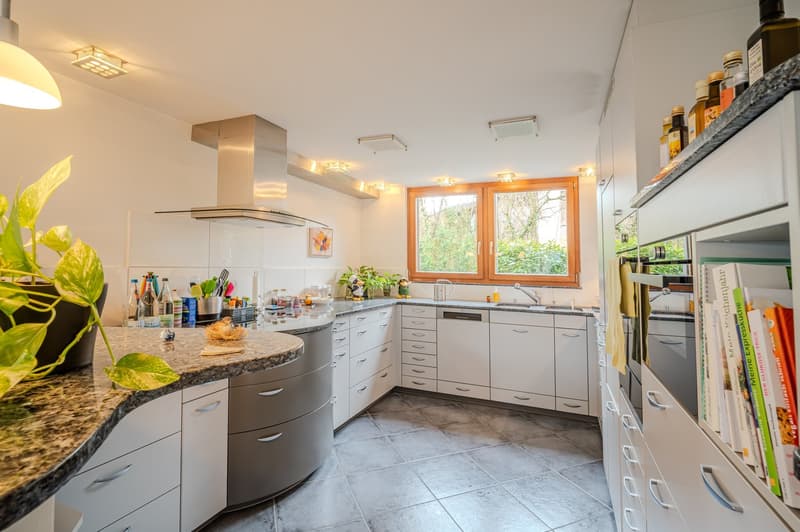 modern kitchen with granite countertops, stainless steel appliances, white cabinets, and a window with wooden frame