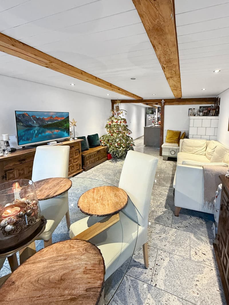 living room with wooden beams, Christmas tree, TV, wooden furniture, white chairs, glass table, couch, fireplace