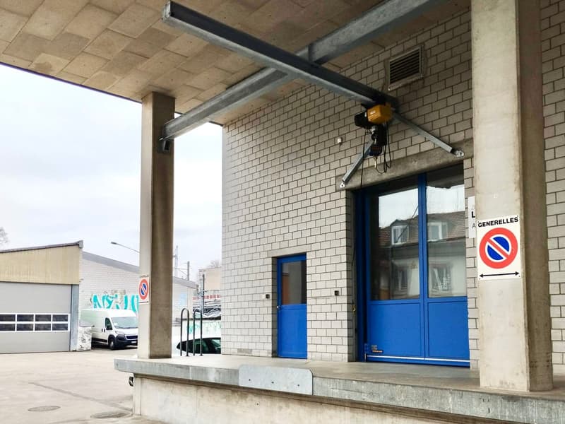 white brick walls, blue glass doors, sign, metal overhead crane