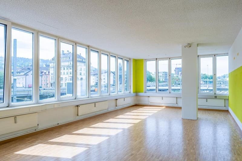 large windows, wooden floor, white walls, yellow accent wall, radiators