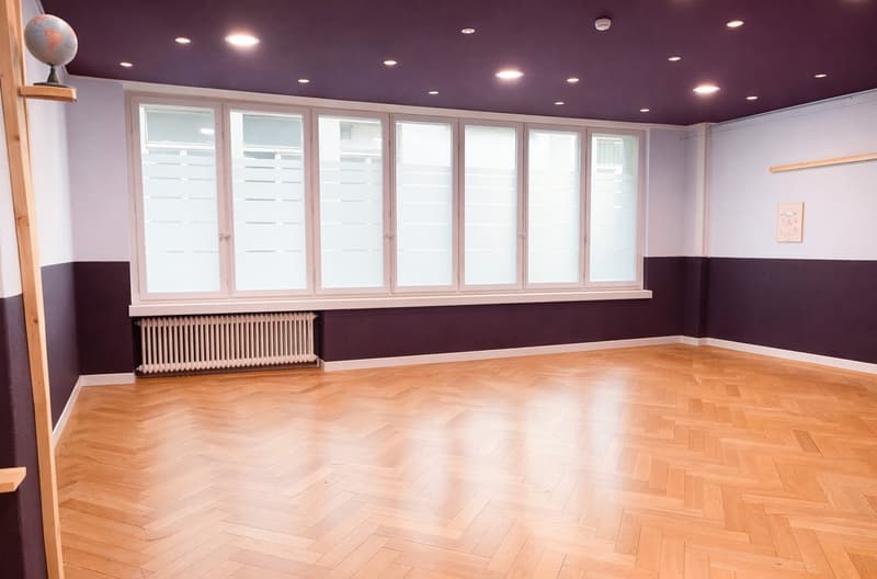empty room, wooden herringbone floor, large windows, radiator