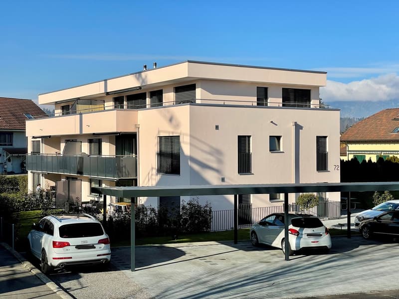 Three story house, white exterior, metal balcony, covered parking, two cars in carport, two cars in street