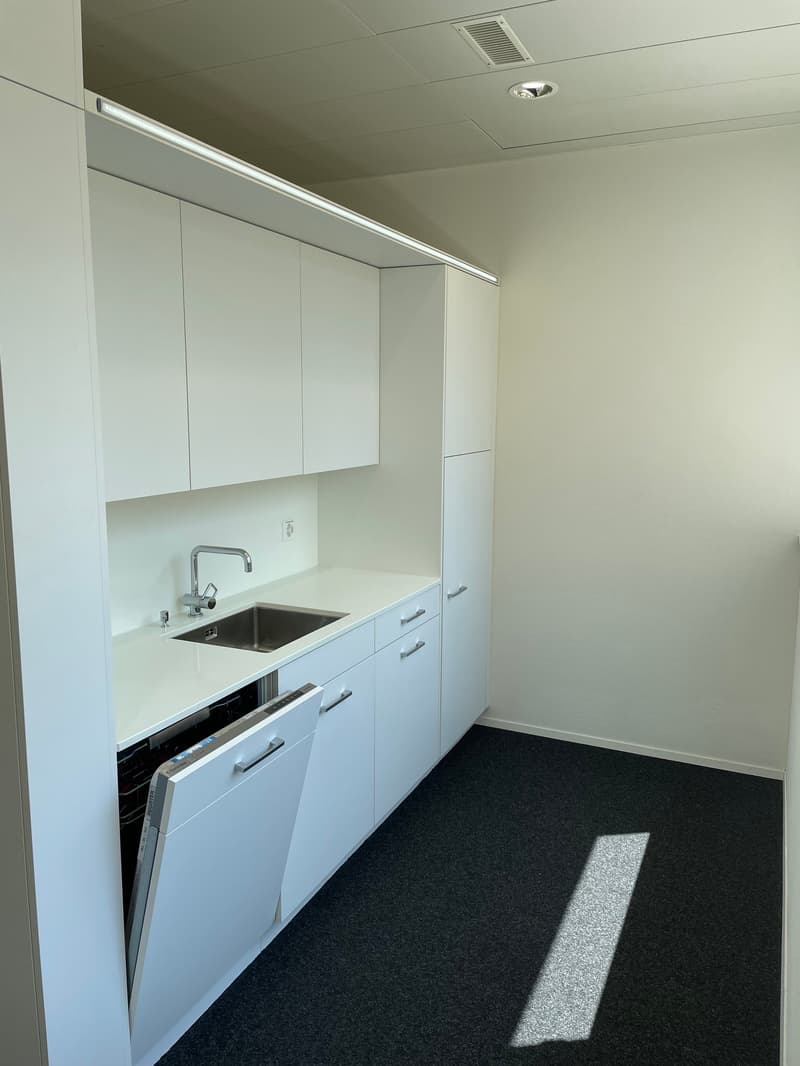 modern kitchen with white cabinets, stainless steel sink, dishwasher, washing machine, and a faucet