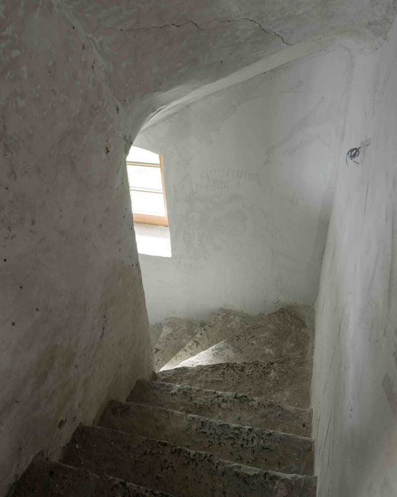 Stone staircase, concrete and stone material, white walls, window on wall, concrete flooring