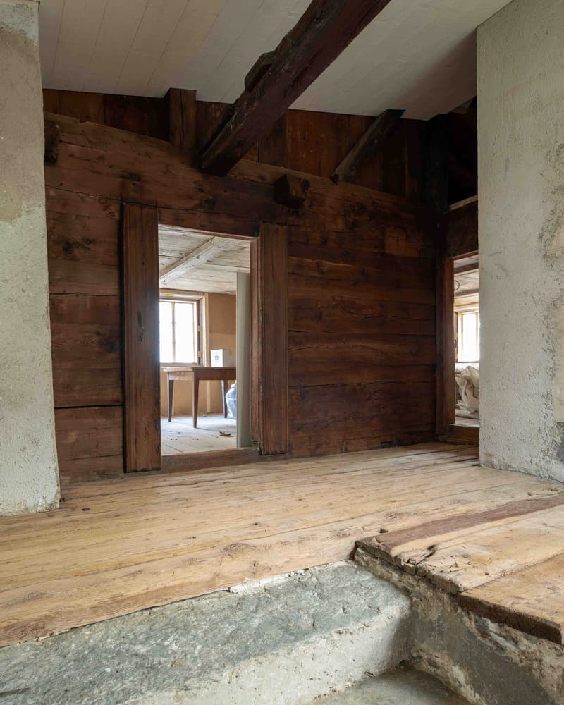 empty room, wooden floor, wooden walls, open doors to another room, wooden table and window, concrete steps